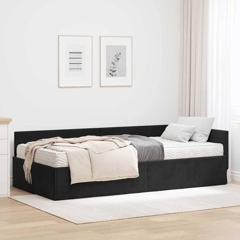Ein minimalistisches Schlafzimmer mit einem schwarzen Speicherbettgestell, weißer Bettwäsche und einer grauen Decke vor einer hellen Wand mit gerahmter Kunst.