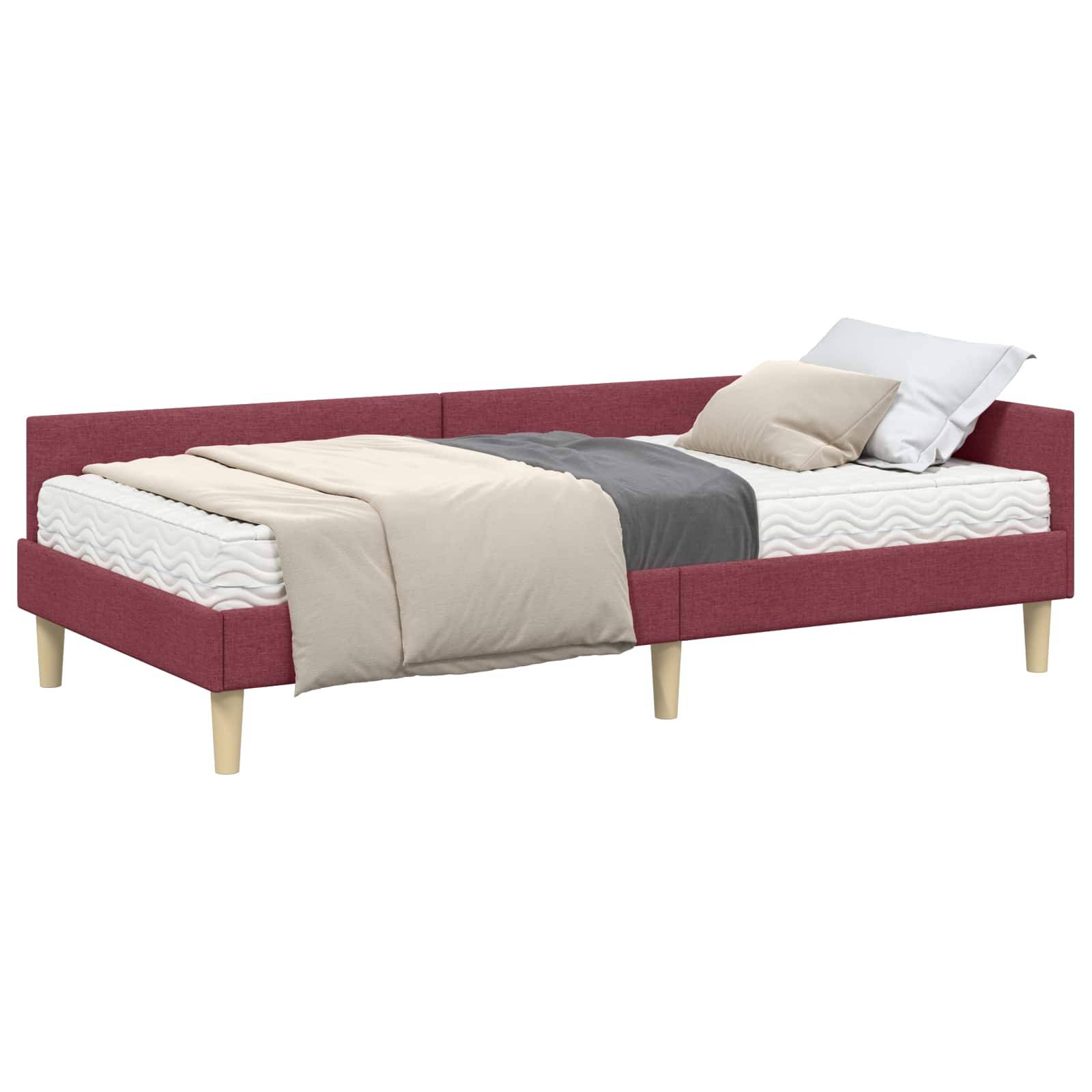 L-förmiges Einzelbett mit roter Polsterung, beige und grauen Decken und zwei Kissen, für eine Schlafzimmereinrichtung konzipiert.