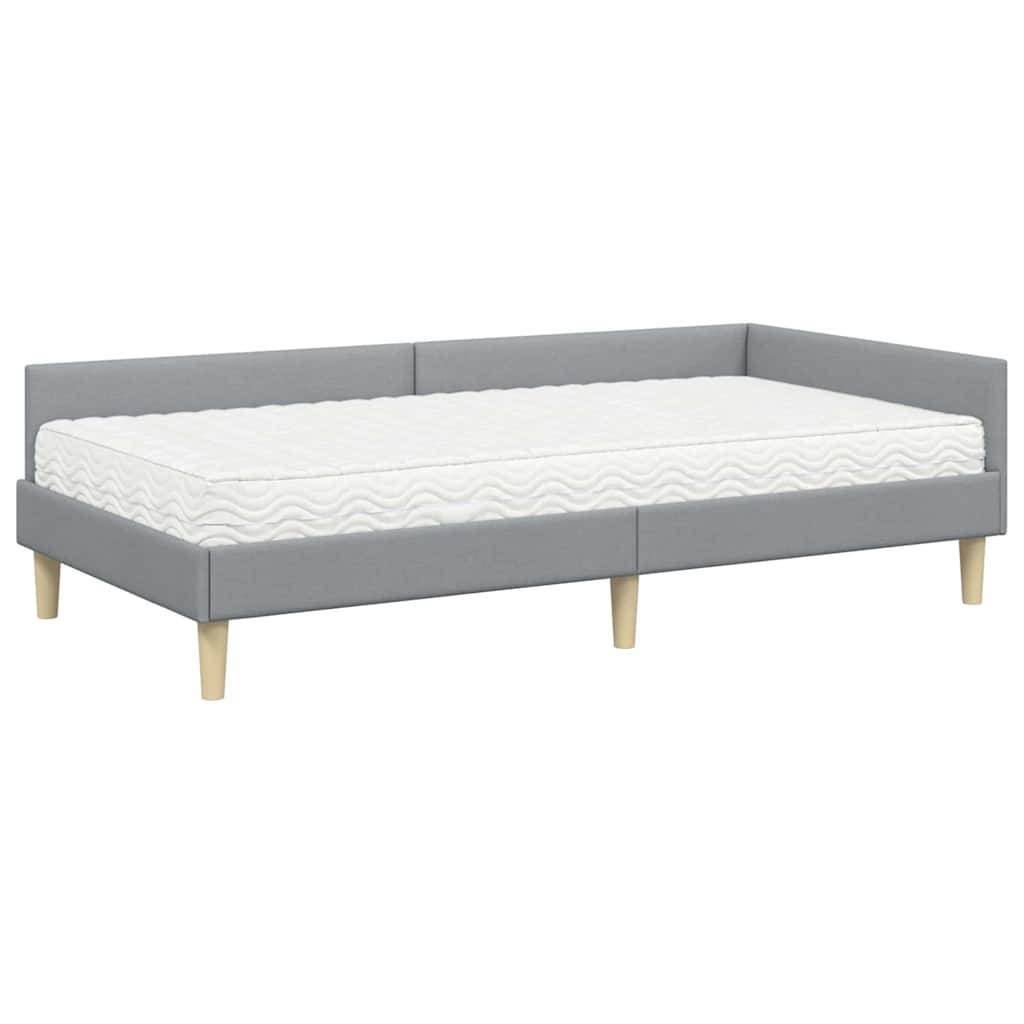 Graues Tagesbett mit hellen Holzbeinen und weißer Matratze, geeignet für moderne Innenräume.