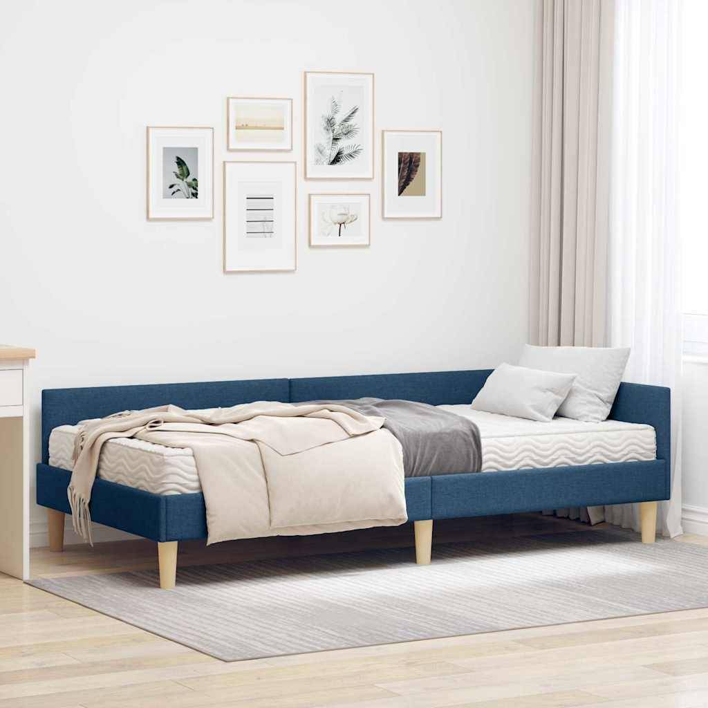Ein modernes Schlafzimmer mit einem Bett aus blauem Stoff, heller Bettwäsche und einer Galeriewand mit sechs gerahmten Bildern darüber. Neutrale Töne schaffen eine gemütliche Atmosphäre.