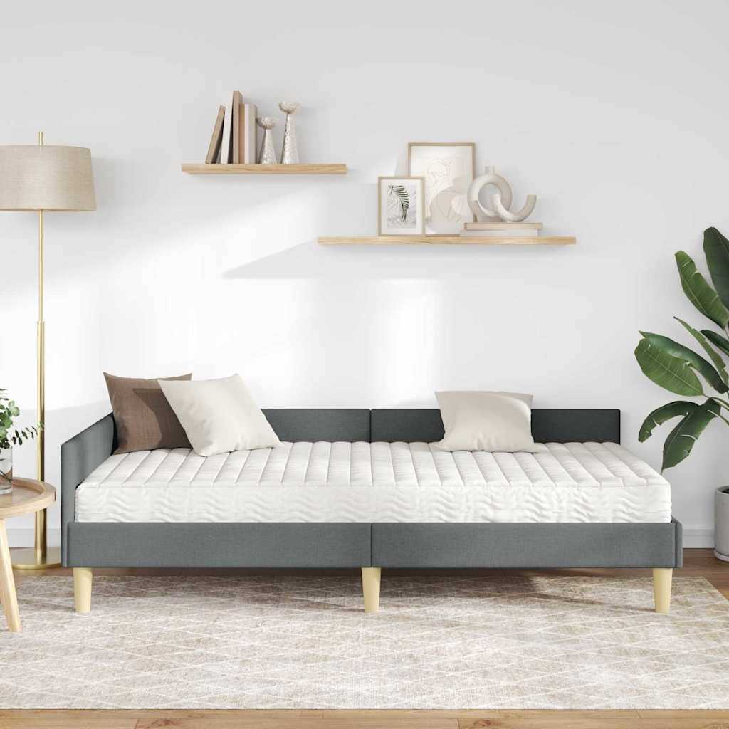 Ein minimalistisches Wohnzimmer mit einem modernen grauen Sofa, zwei schwebenden Regalen mit Dekorationsgegenständen, einer hohen Stehlampe und einer Topfpflanze.