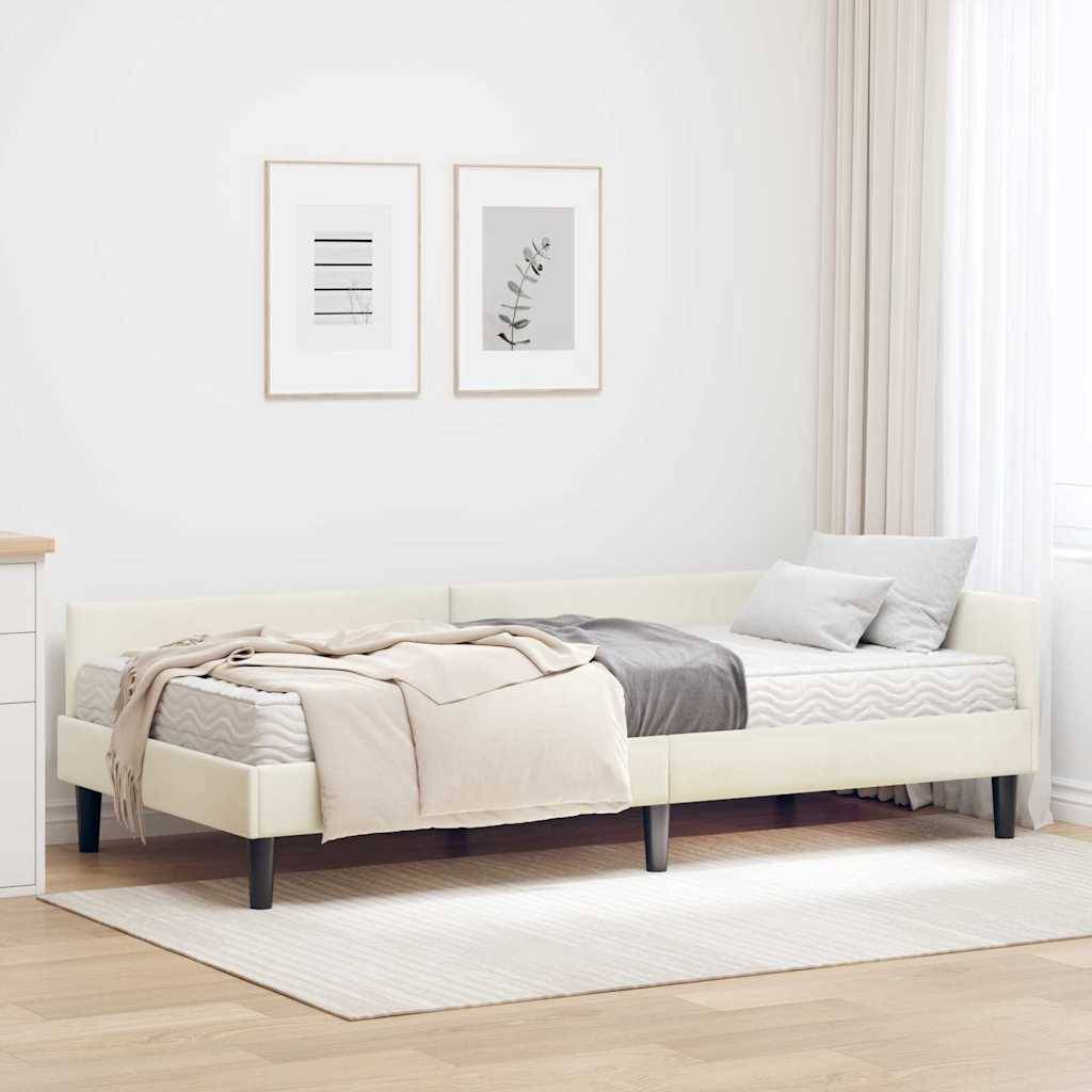 Ein ordentlich gemachtes Bett mit beige und grauer Bettwäsche befindet sich in einem minimalistischen, hell erleuchteten Schlafzimmer. Zwei gerahmte Kunstwerke und eine hohe Kommode sind sichtbar.