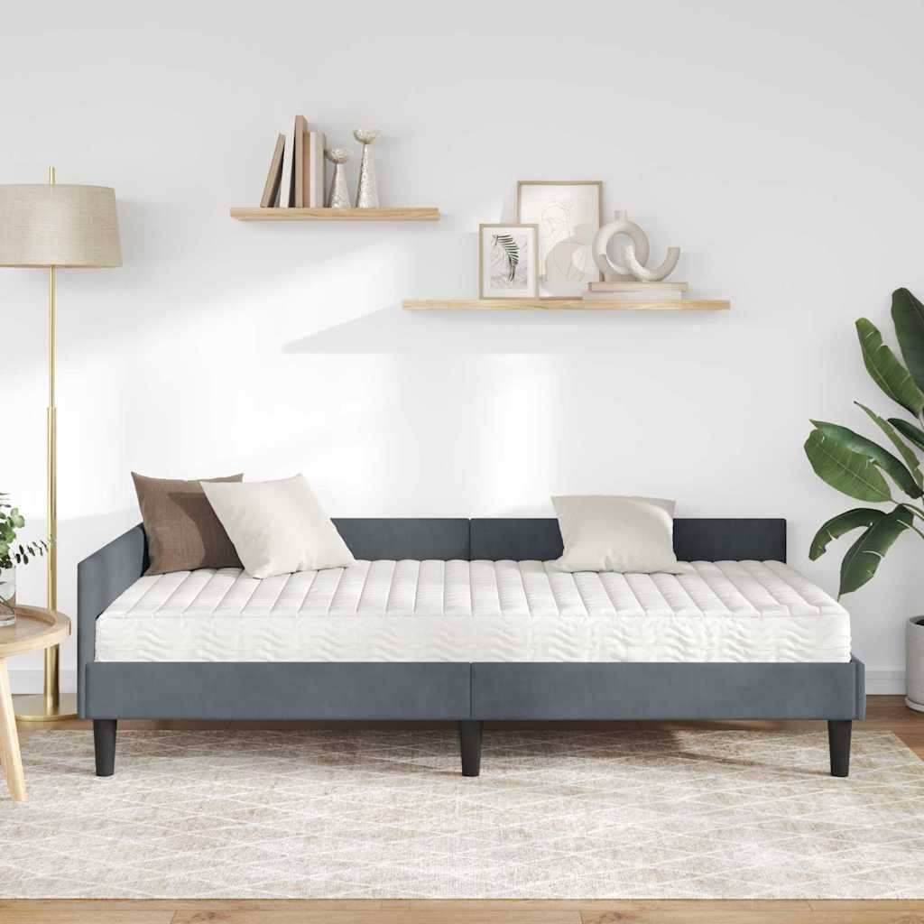 Ein modernes Wohnzimmer mit einem minimalistischen grauen Sofa, beigen Kissen und abstrakter Wandkunst. Eine hohe Stehleuchte und eine Topfpflanze dienen als Dekoration.
