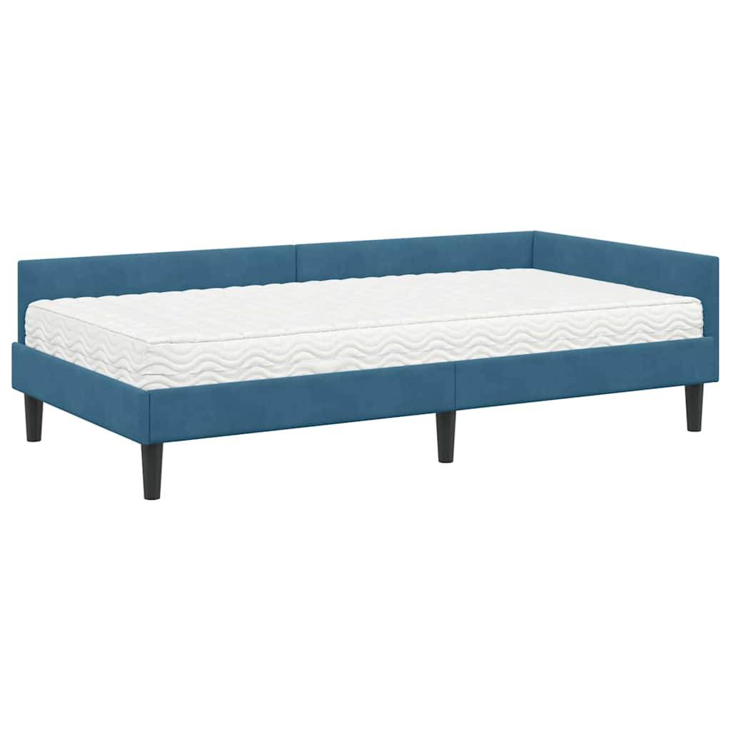Ein blaugepolstertes Tagesbett mit weißer Matratze und einfachen schwarzen Beinen.