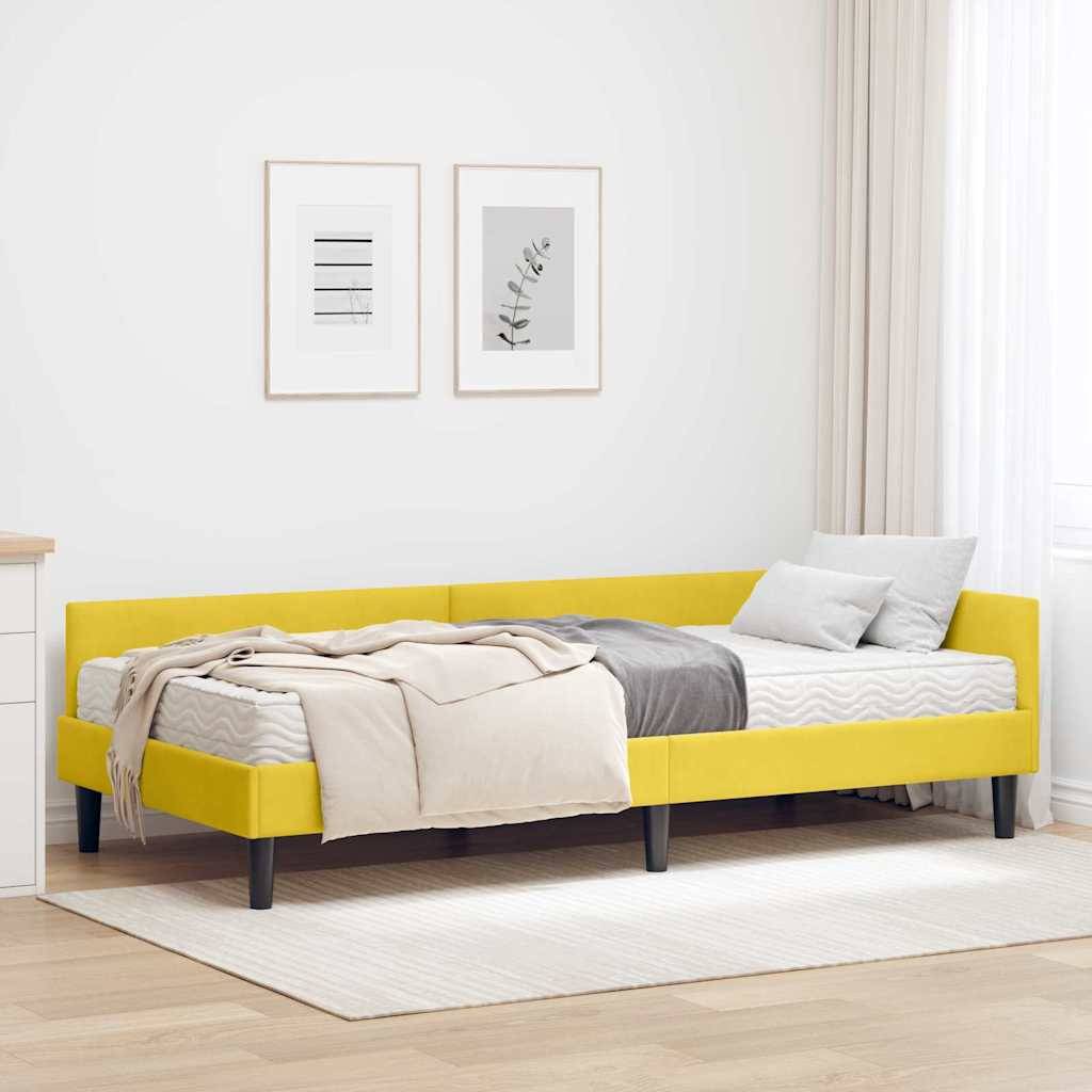 Ein strahlend gelbes Schlafsofa in einem minimalistischen Zimmer mit zwei gerahmten Bildern an der Wand und einer kleinen weißen Kommode in der Nähe.