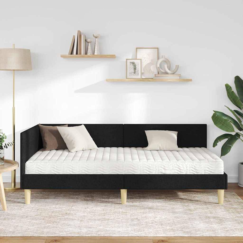 Ein modernes Wohnzimmer mit einem schwarzweißen Sofa, einer Stehleuchte, zwei Wandregalen mit Dekoration und einer großen Pflanze in der Ecke.