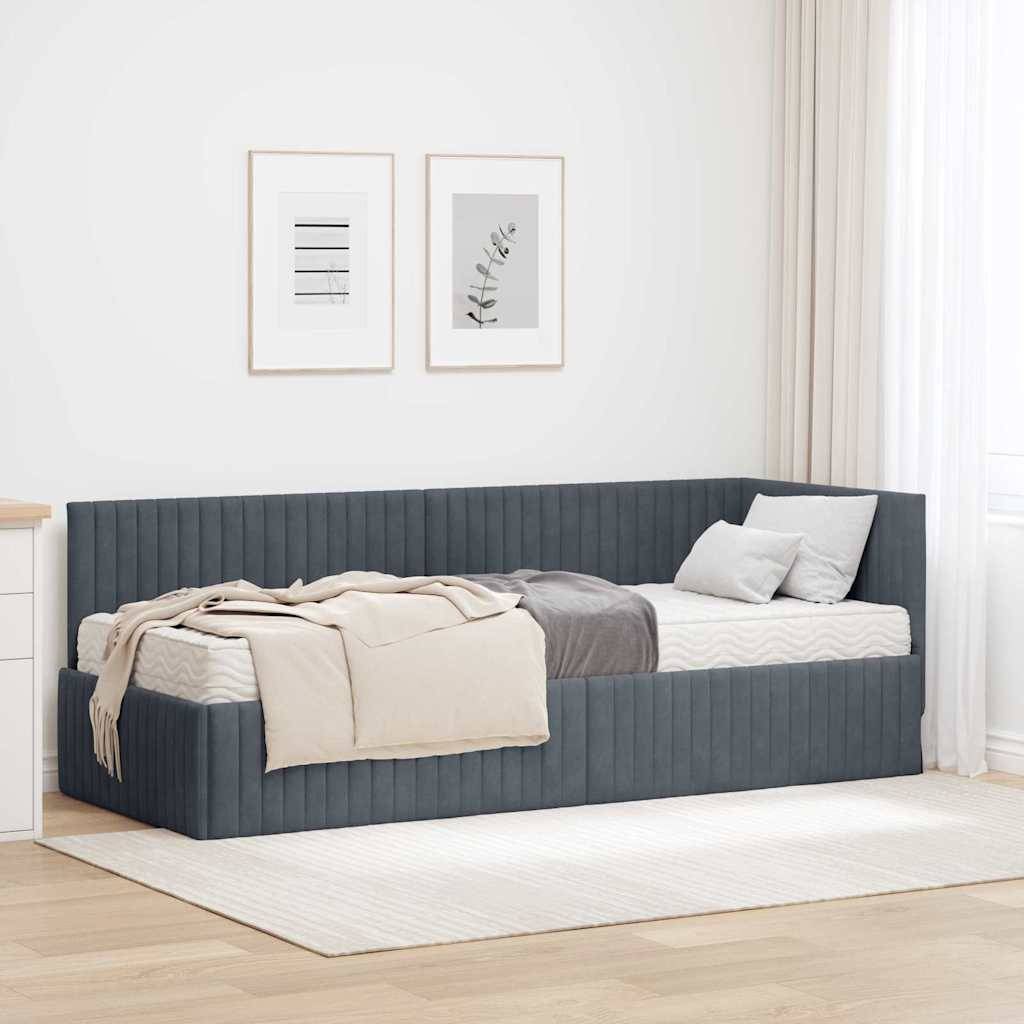 Ein minimalistisches Schlafzimmer zeigt ein graues Tagesbett mit weißer und beiger Bettwäsche unter gerahmter Kunstwerk an einer hellen Wand, platziert auf einem weichen Teppich.