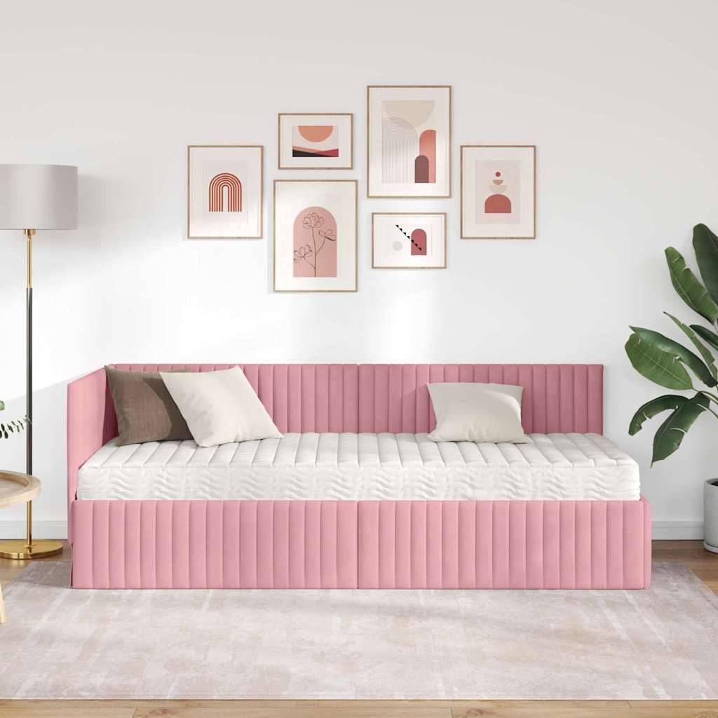 Ein moderner Raum zeigt ein pinkes gepolstertes Tagesbett mit beigen und weißen Kissen, eine Stehlampe, eine Zimmerpflanze und abstrakte Kunst an der Wand.
