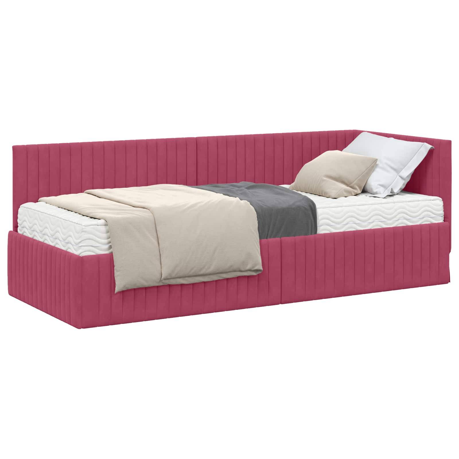 Ein rotes Tagesbett mit einem gepolsterten Rückenlehnen, versehen mit weißer, grauer und beiger Bettwäsche.