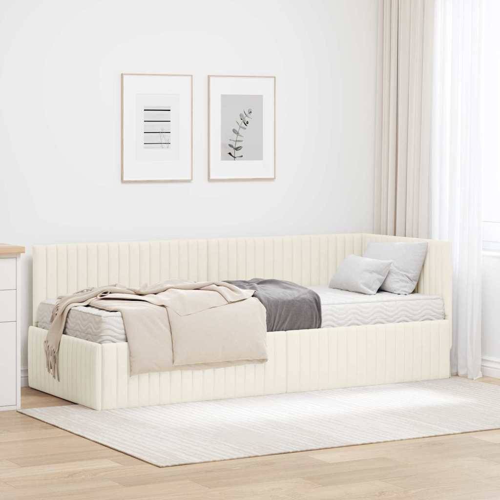 Ein minimalistisches Schlafzimmer mit einer beigen Tageliege, neutralen Zierkissen und einer hellgrauen Decke. Zwei gerahmte abstrakte Drucke hängen über dem Bett.