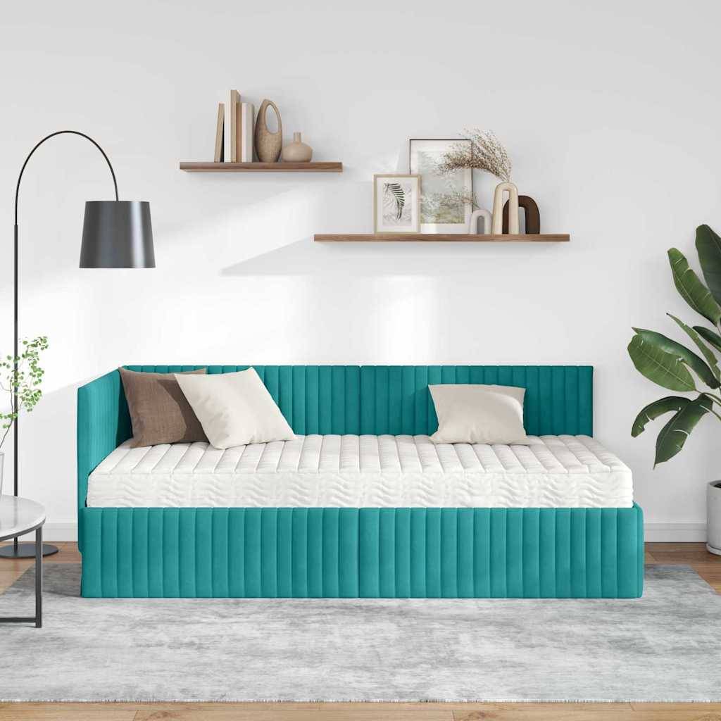 Ein modernes Tagesbett in Blaugrün mit weißen und braunen Kissen ist in einem minimalistischen Wohnzimmer angeordnet. Eine Stehlampe, schwebende Regale und eine Pflanze vervollständigen die Einrichtung.