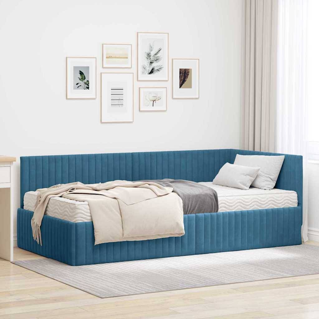 Ein modernes Schlafzimmer mit einer blau gepolsterten Tagesbett, beigefarbener Bettwäsche und Wandkunst mit Naturmotiven. Helles, natürliches Licht durchflutet den Raum.