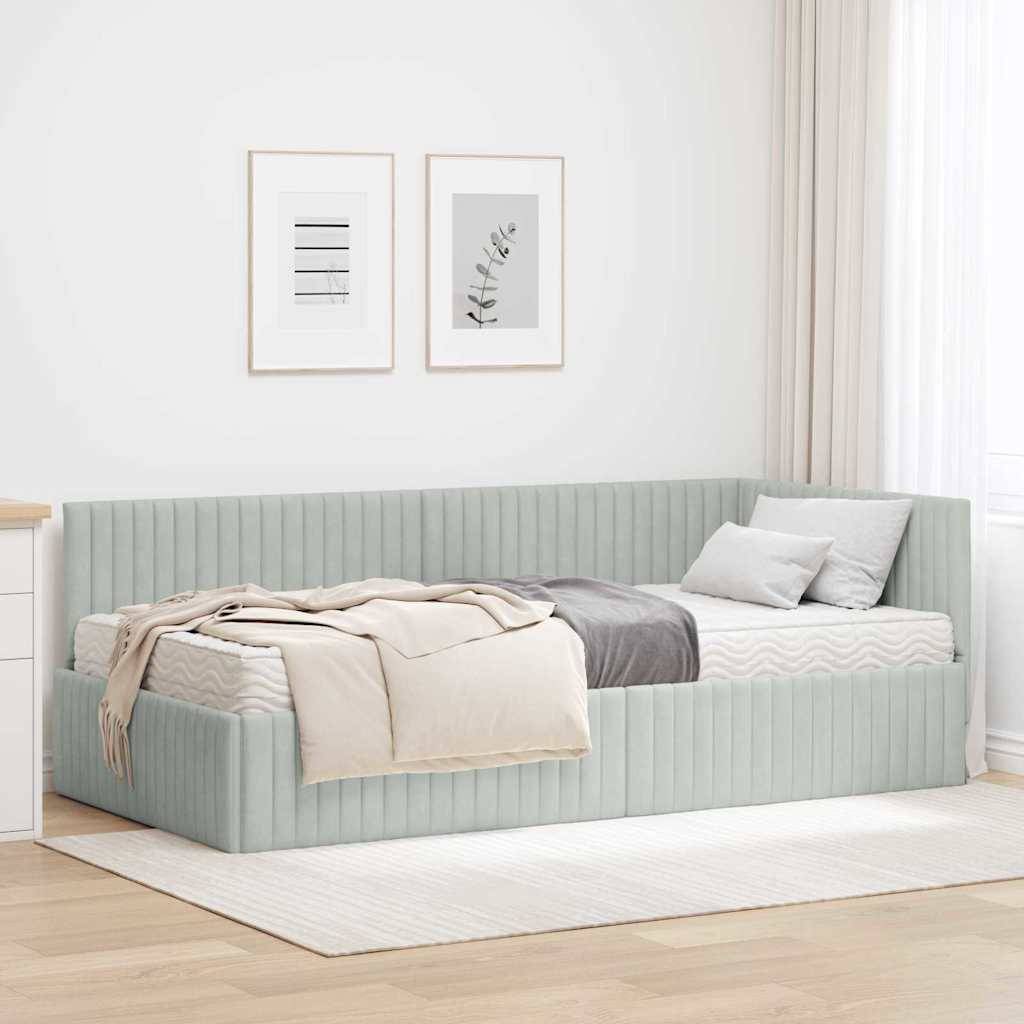 Ein minimalistisches Zimmer mit einem hellgrauen Tagesbett, grauer Bettwäsche und Kissen. Zwei eingerahmte Kunstwerke hängen darüber an einer weißen Wand.