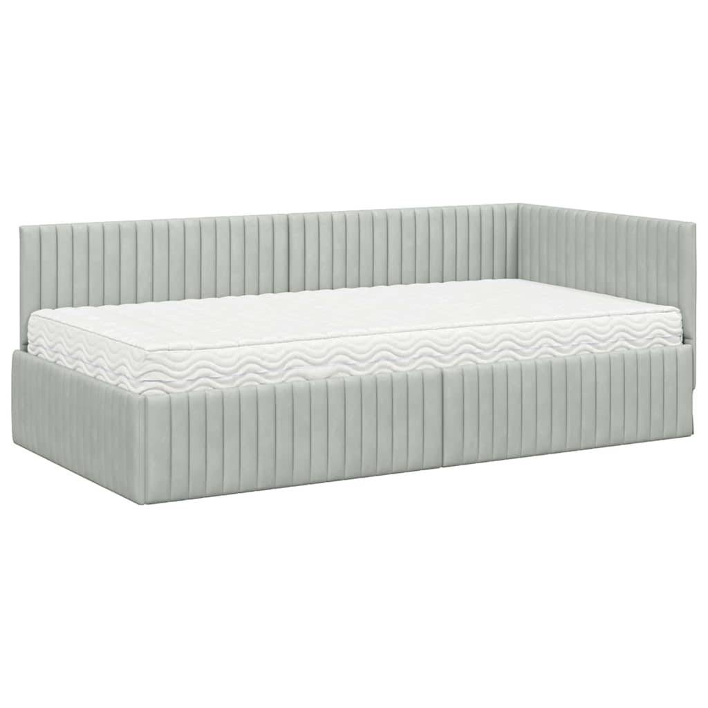 Ein grau gepolstertes Tagesbett mit vertikalen Nähten und einer weißen Matratze. Das Bett verfügt über einen gepolsterten Rücken und Seiten, die einen gemütlichen Sitzbereich schaffen.