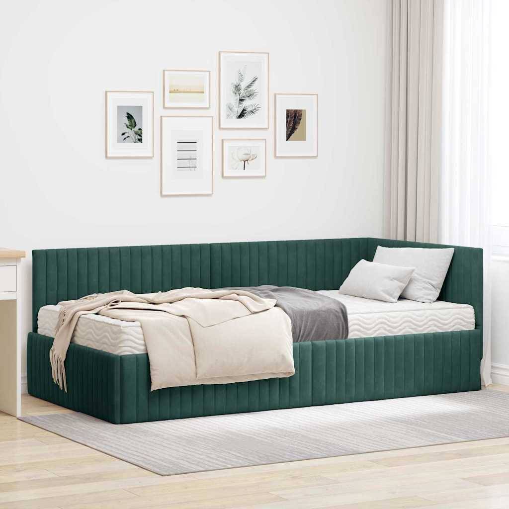Ein gemütliches Schlafzimmer mit einer grünen Tagesbett, weißer und beiger Bettwäsche und gerahmter Kunstwerken an einer weißen Wand. Ein Schreibtisch ist links teilweise zu sehen.
