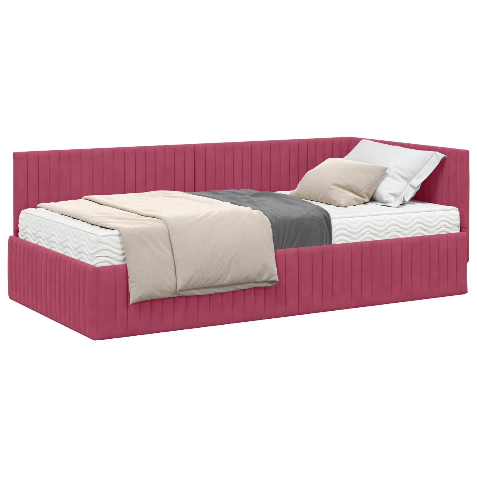 Ein helles rotes Tagesbett mit einer Matratze, beige und grauen Bettwächen und einem Kissen gegen die Rückenlehne, was einen modernen minimalistischen Stil andeutet.