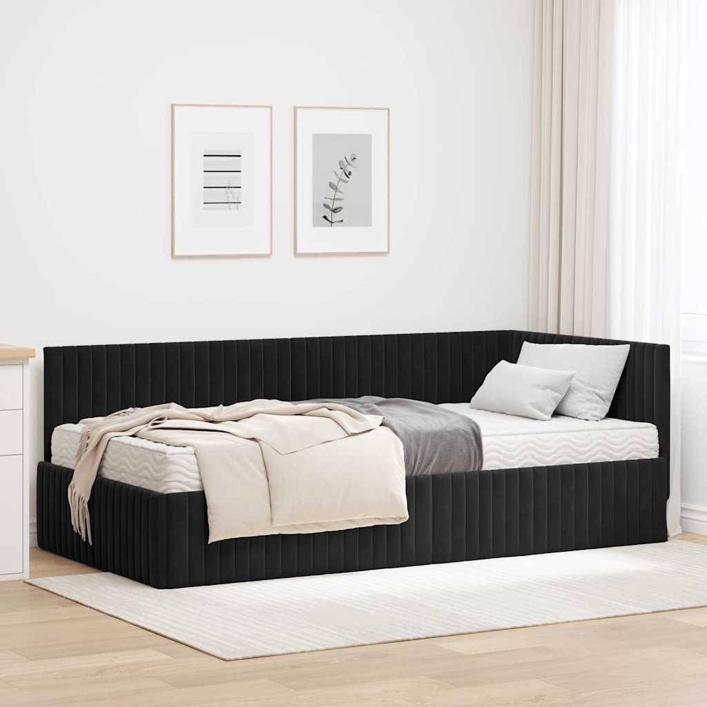 Ein modernes schwarzes Tagesbett mit gestreifter Matratze, hell grau und beige bezogener Bettwäsche, platziert in einem minimalistischen Raum mit weißen Wänden und gerahmter Kunst.
