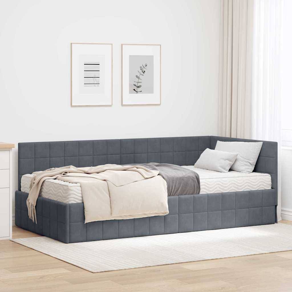 Ein modernes Schlafzimmer präsentiert eine graue gesteppte Tagesbettliege mit neutrafarbener Bettwäsche und Kissen, die vor einer weißen Wand mit gerahmter Kunst positioniert ist.
