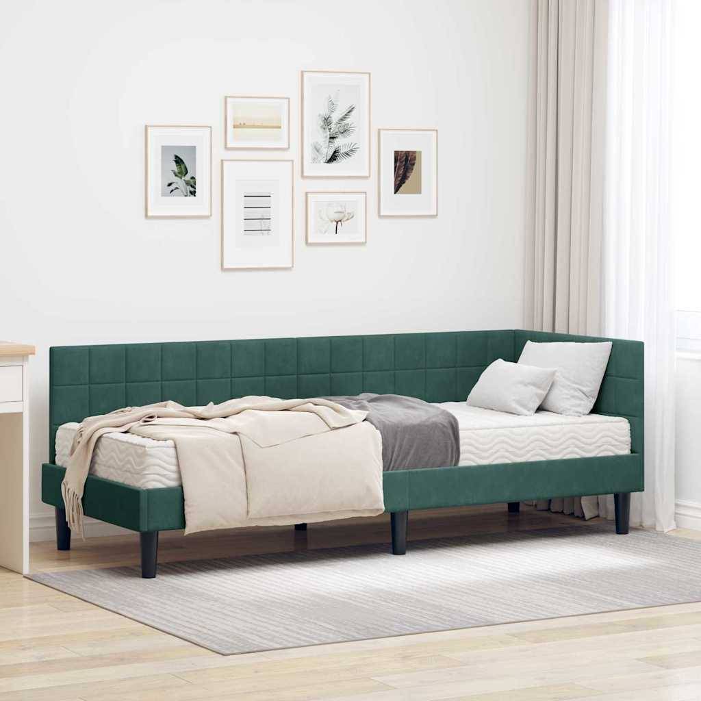 Ein modernes Schlafzimmer mit einem dunkelgrünen Tagesbett, geschmückt mit gemütlichen Kissen und einer beigen Decke, das vor einer Wand mit gerahmter Kunstwerken und einem Vorhang steht.