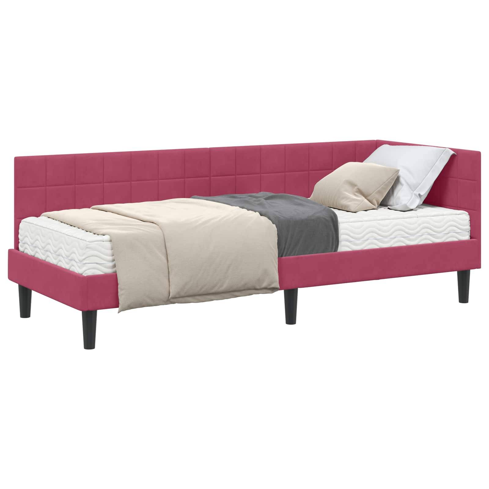 Rosa gepolstertes Tagesbett mit kariertem Kopfteil, ausgestattet mit weißer und grauer Bettwäsche und Kissen. Es hat schwarze Beine und ein modernes Design.