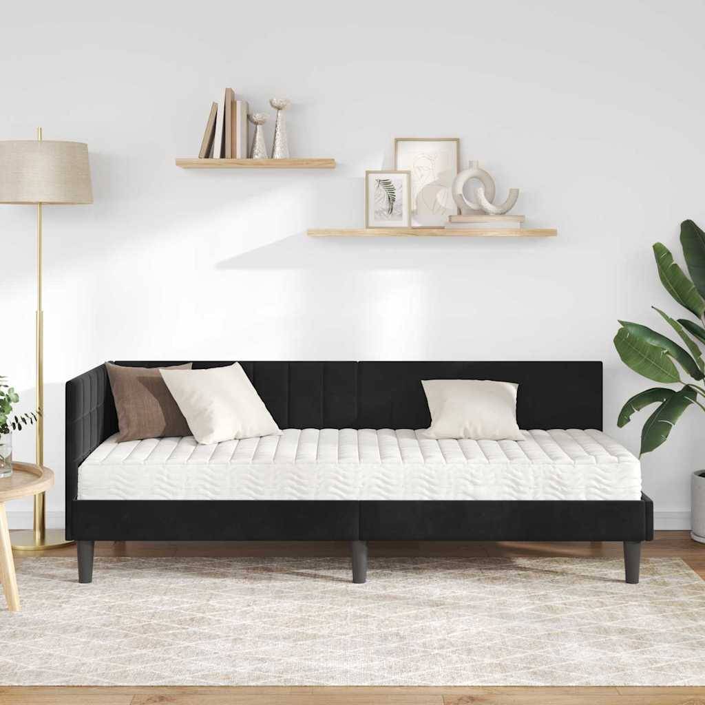 Ein moderner Raum präsentiert ein schwarzes Tagesbett mit weißen Kissen, umgeben von einer Stehlampe, Wandregalen mit Dekoration und einer großen Pflanze.
