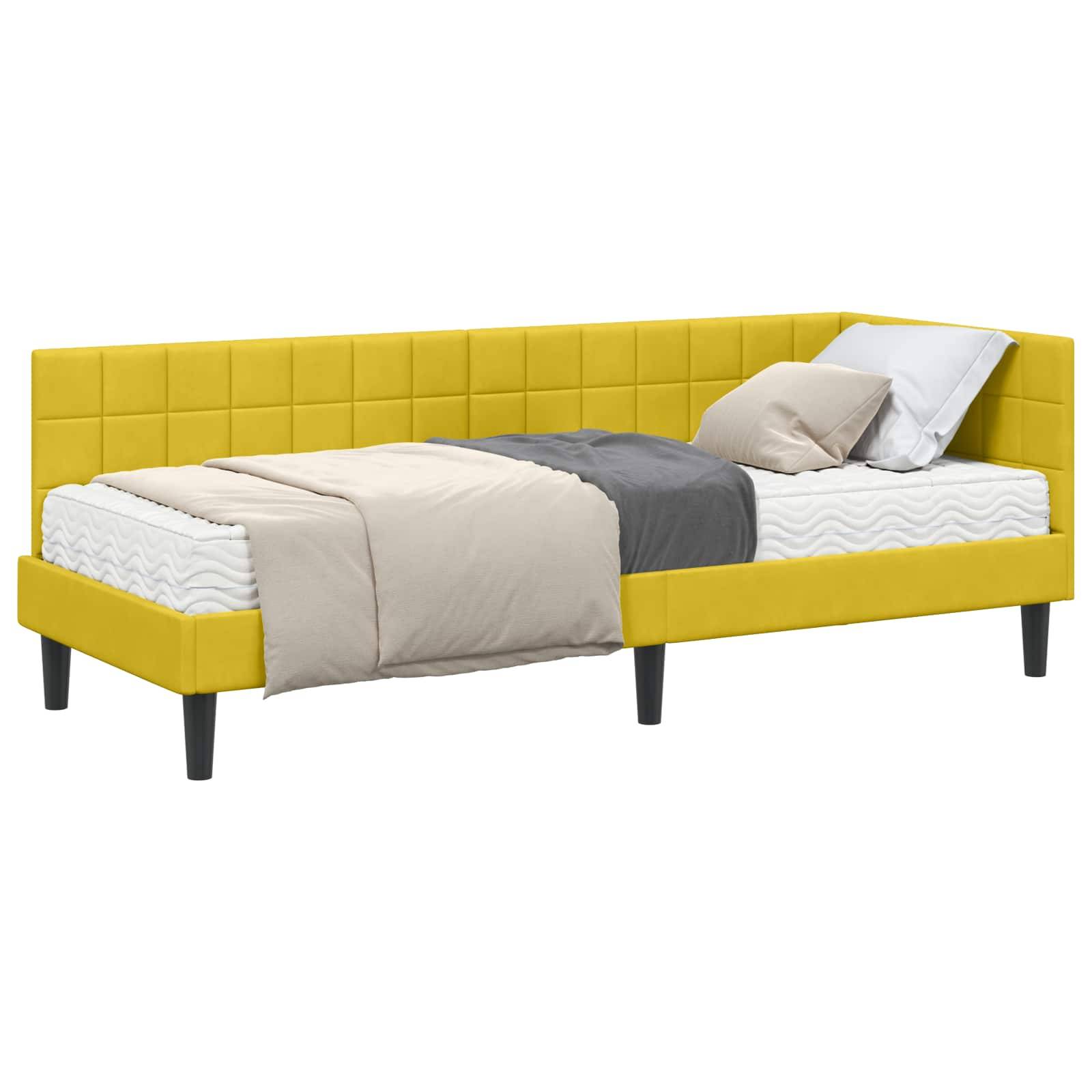 Eine gelbe gepolsterte Tagesbett mit minimalistischem Design, ausgestattet mit einer Matratze, grauen und beigen Decken sowie zwei weißen Kissen.