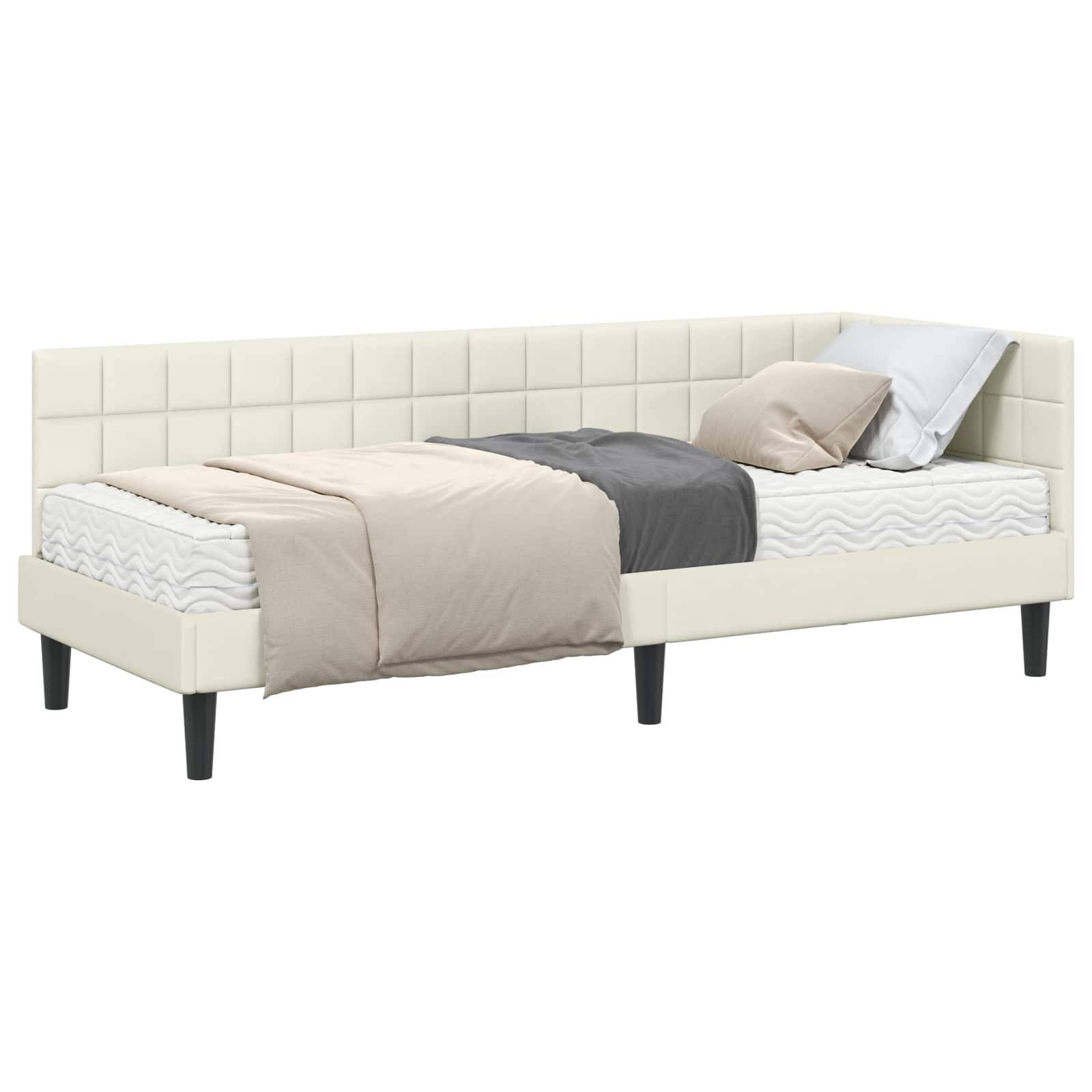 Ein weißes gepolstertes Tagesbett mit zwei Rückenkissen und einem Bettwäsche-Set, das eine hellbraune Decke, ein graues Laken und ein weißes Kissen umfasst.