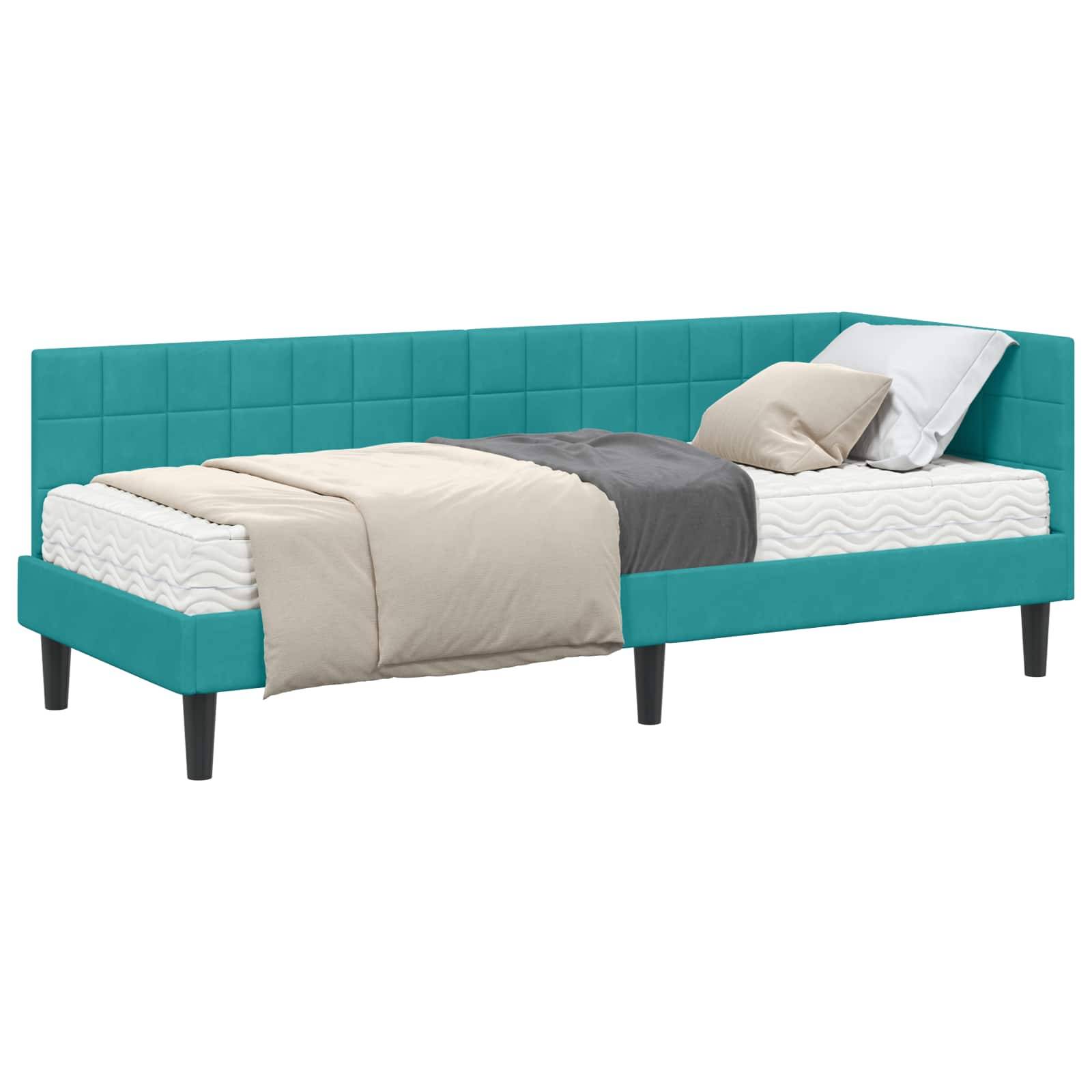 Ein türkisfarbenes gepolstertes Tagesbett mit einer weißen Matratze, beige und grauen Bettwaren und einem Kissen. Das Bett hat ein modernes gestepptes Design.
