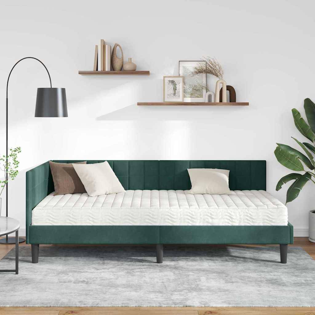 Ein minimalistisches Schlafzimmer zeigt ein modernes grünes Bett mit weißen und beigen Kissen, eine Stehlampe und Regale mit Dekorationen an einer weißen Wand.