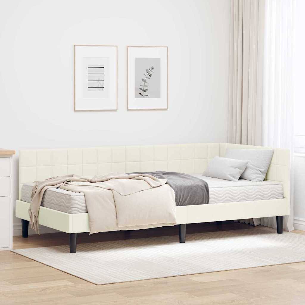 Ein modernes Schlafzimmer mit einem cremefarbenen Bett in der Ecke, grauen Bettwäsche und einer beigen Decke. Zwei gerahmte Drucke hängen an der Wand über dem Bett.