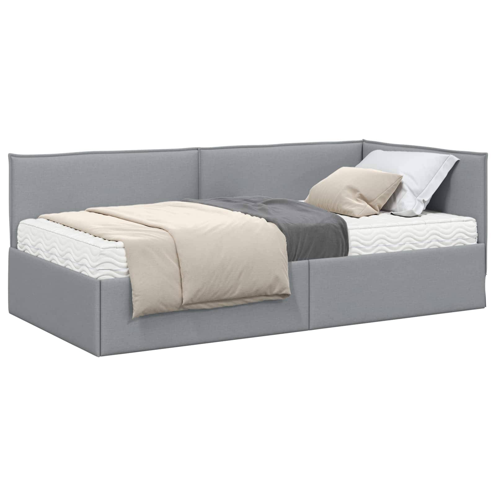 Ein graues gepolstertes Tagesbett mit einer Matratze, grau-beigen Bettwaren und Kissen, konzipiert für vielseitige Nutzung als Sofa oder Bett.