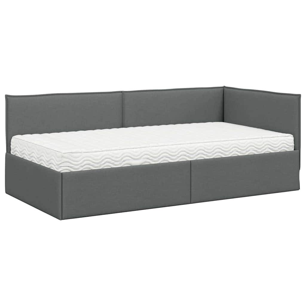 Ein graues Tagesbett mit einem einfachen, gepolsterten Design und einer weißen Matratze, das sowohl Sitz- als auch Schlafplatz bietet.
