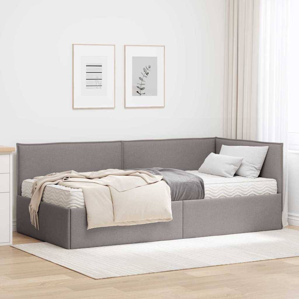 Ein lichtdurchflutetes Schlafzimmer mit einer grauen und beigen Eckschlafcouch, weißer Kommode, zwei gerahmten Wandbildern und neutraler Dekoration.