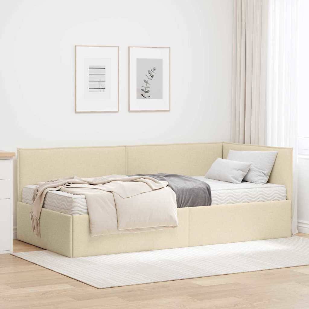 Ein gemütliches beiges Tagesbett mit Kissen und einer Decke in einem minimalistischen Raum, geschmückt mit zwei gerahmten Kunstwerken an einer weißen Wand.