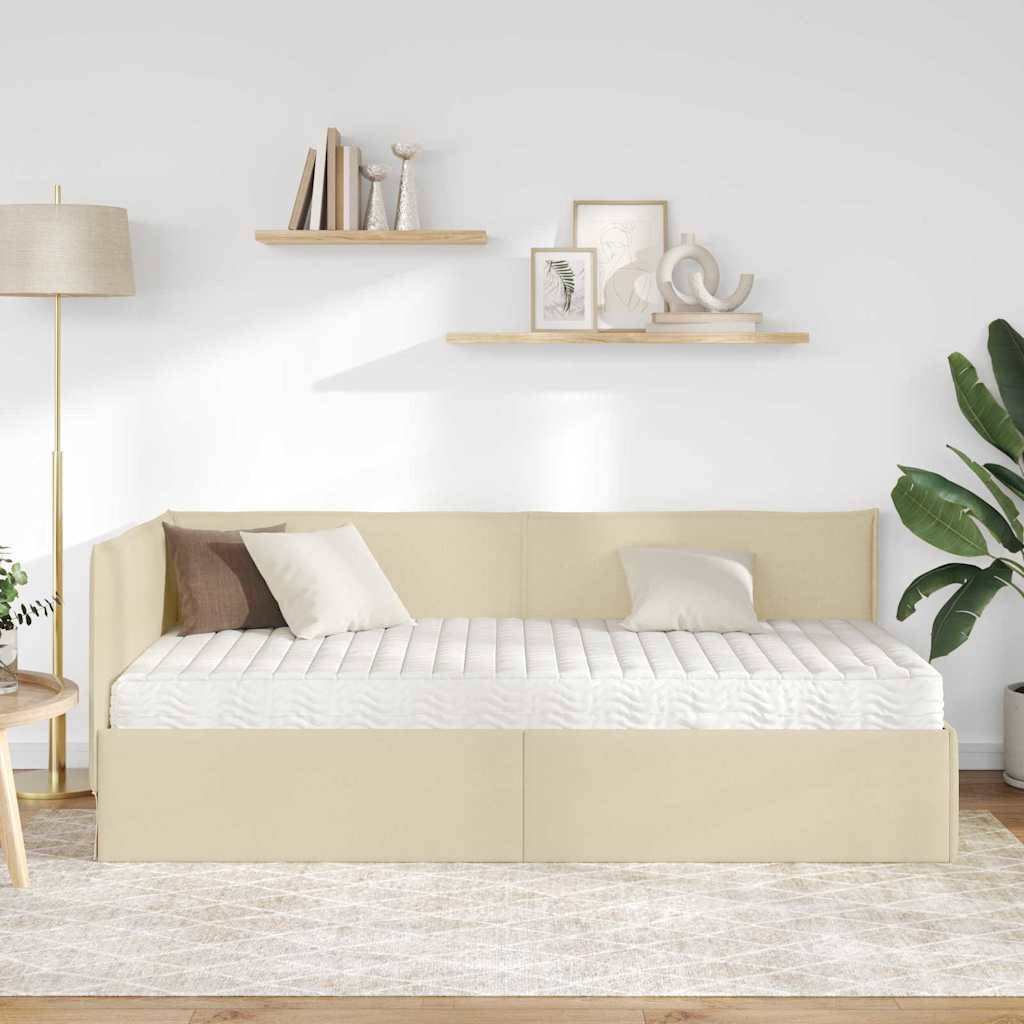 Eine beige Tagesbett in einem modernen Wohnzimmer, flankiert von einer Stehlampe und Regalen mit Dekorationselementen, vor einer hellfarbenen Wand.