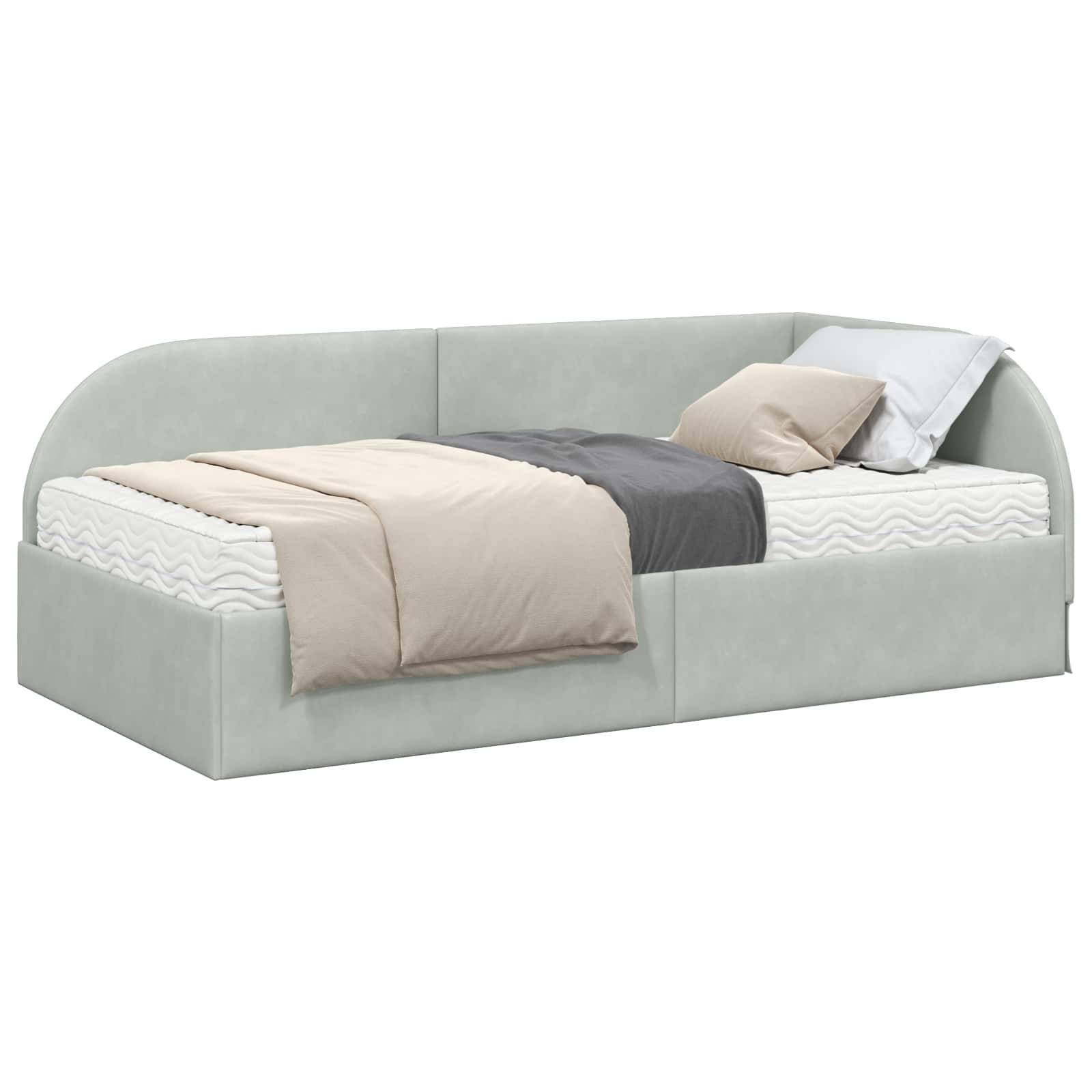 Ein modernes Tagesbett mit einem hellgrauen gepolsterten Gestell, belegt mit beige- und grauen Bettwächen und weißen Kissen, vor einem schlichten Hintergrund.