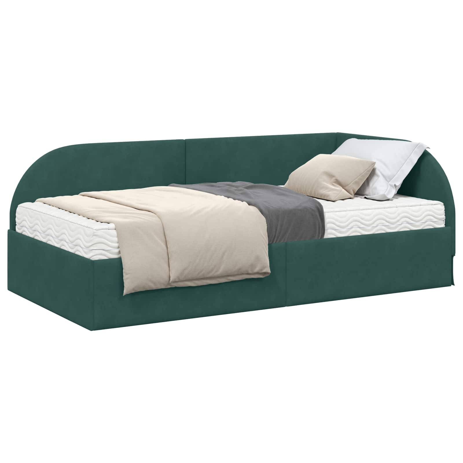 Ein modernes Tagesbett mit einem grün gepolsterten Rahmen zeigt eine ordentlich bezogene Matratze, beige Bettwäsche und graue Kissen, aufgenommen aus einem Seitenwinkel.