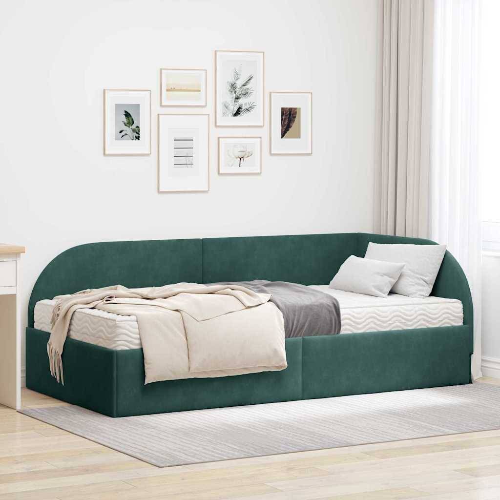 Ein modernes minimalistisches Schlafzimmer zeigt ein grünes Tagesbett mit grau-beiger Bettwäsche, einem hellen Teppich und gerahmter Kunst an einer weißen Wand.