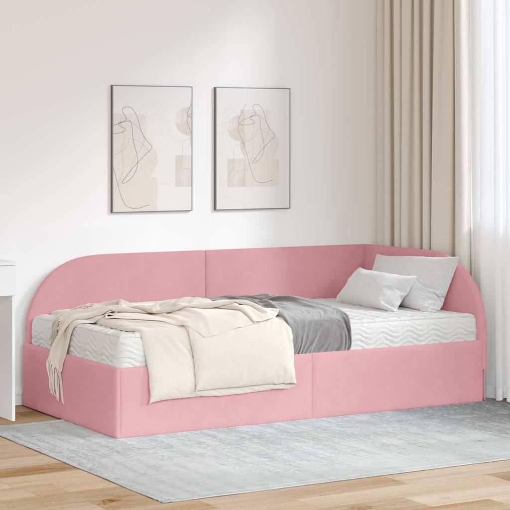 Ein gemütliches Schlafzimmer zeigt ein rosa Eckbett mit einer cremefarbenen Tagesdecke und grauen Kissen. Zwei abstrakte Drucke hängen darüber und verschönern die Dekoration.