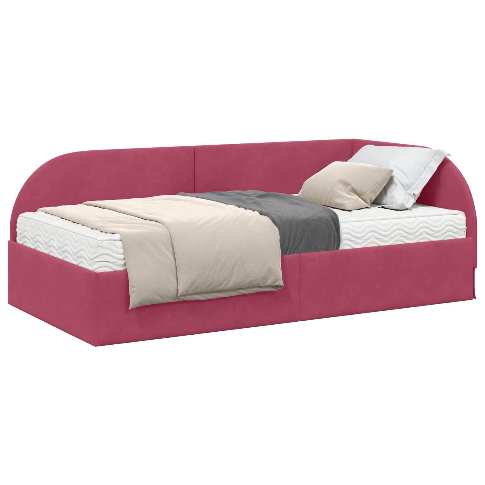Ein rosa gepolstertes Tagesbett mit einer grau-beigen Bettdecke, Betttüchern und zwei weißen Kissen. Gemütlich arrangiert für eine moderne Schlafzimmergestaltung.
