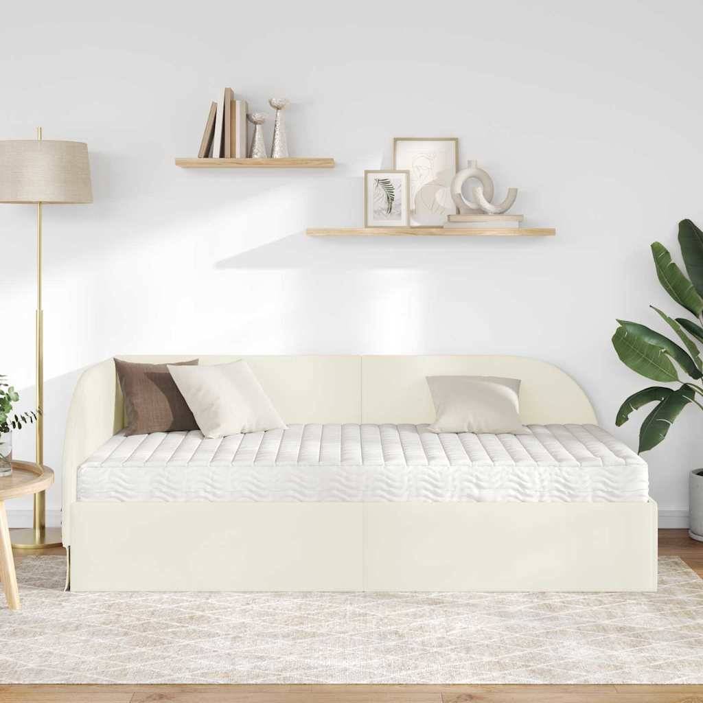 Ein modernes Wohnzimmer mit einem cremefarbenen Sofa mit gestreiften Kissen, zwei Holzregalen mit Dekoration, einer hohen Stehlampe und einer großen Zimmerpflanze.