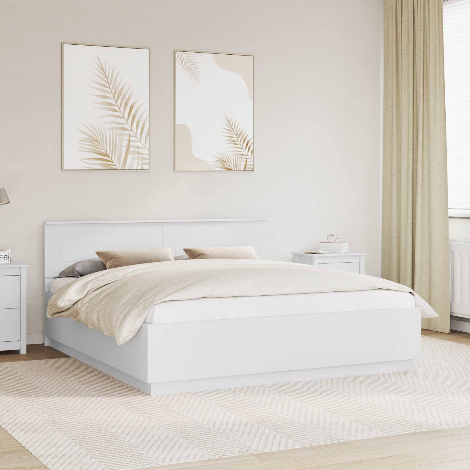 Ein minimalistisches modernes Schlafzimmer mit einem weißen Bett, beigefarbener Bettwäsche und einem geometrischen Teppich. Zwei abstrakte botanische Kunstwerke hängen über dem Bett.