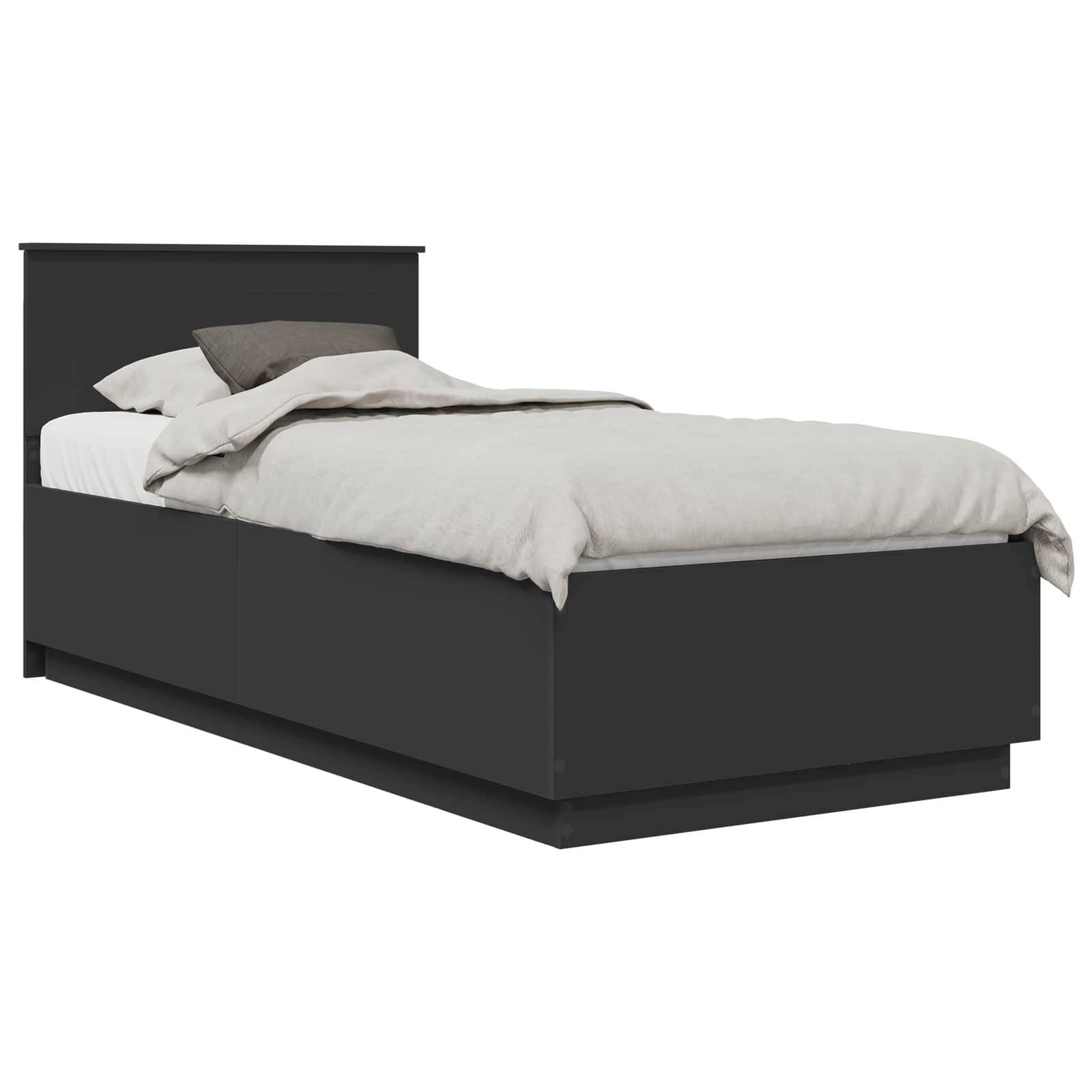 Ein schwarzes Einzelbett mit Kopfteil, ausgestattet mit weißer und grauer Bettwäsche und Kissen.