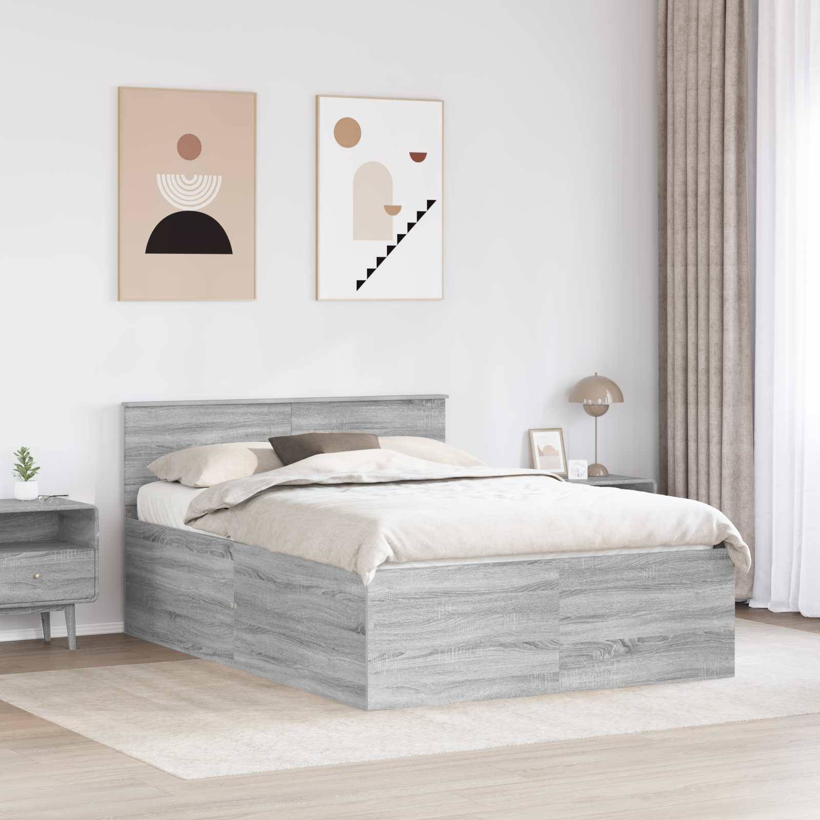 Ein modernes Schlafzimmer mit einem grauen Holzbett, beigen Bettwäsche, zwei abstrakten gerahmten Kunstwerken darüber und einem Nachttisch mit einer Lampe und Dekorationselementen.