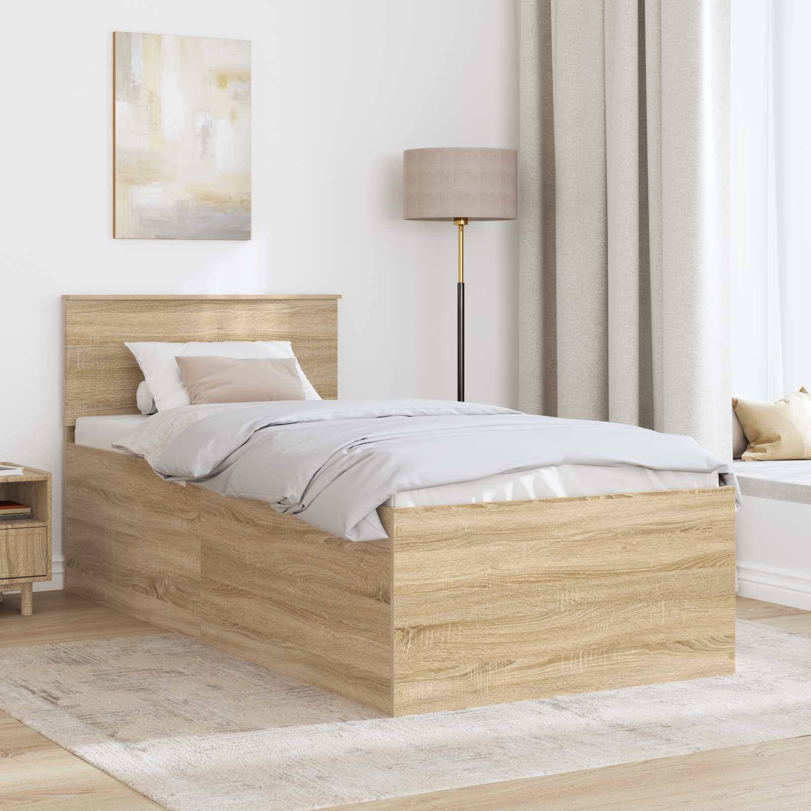 Ein modernes Schlafzimmer zeigt ein Bett aus hellem Holz mit grauer Bettwäsche, einem Nachttisch und einer Stehlampe. Neutrale Farbtöne und weiche Texturen erzeugen eine ruhige Atmosphäre.