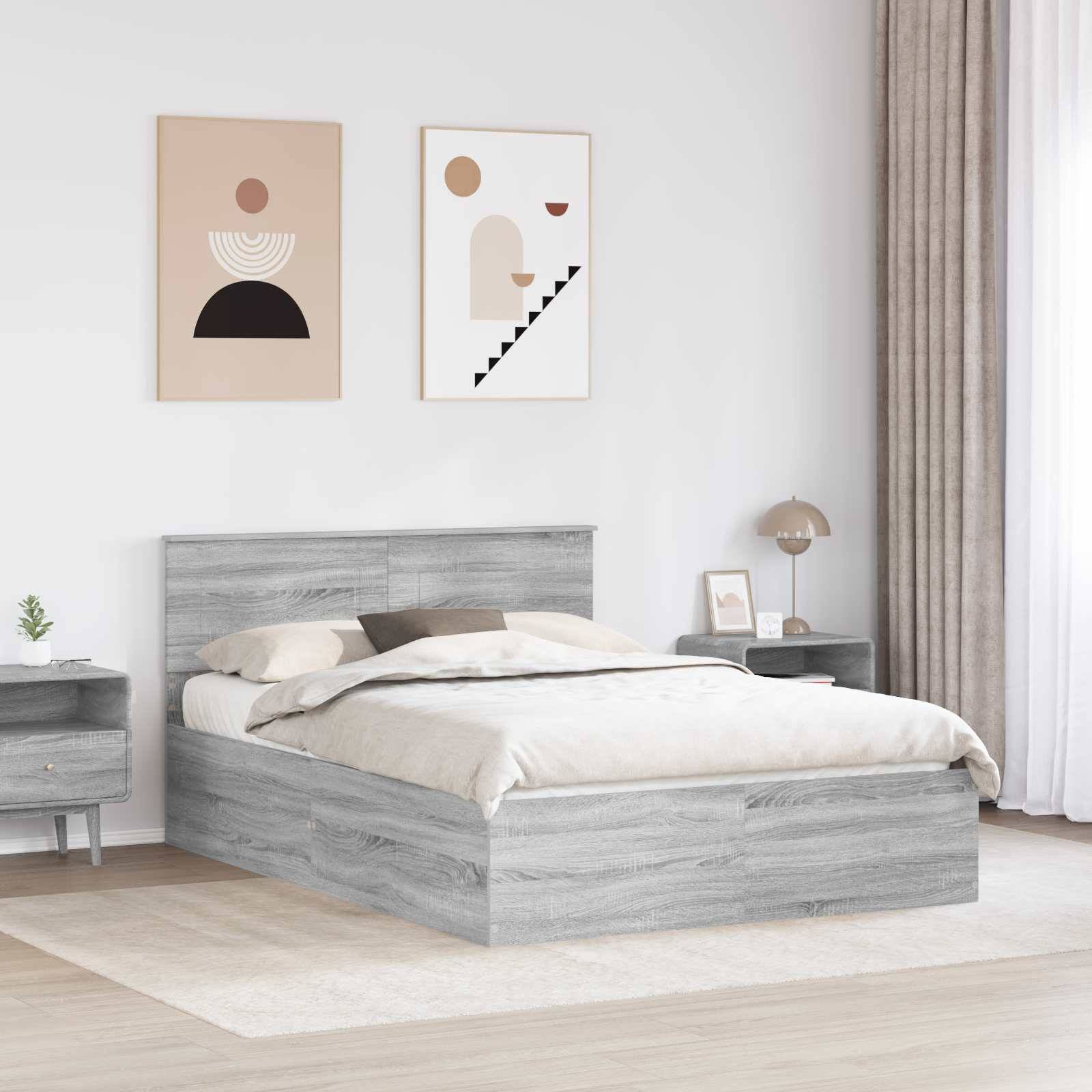 Ein modernes Schlafzimmer präsentiert ein graues Holzbett mit neutraler Bettwäsche. Zwei geometrische Kunstdrucke hängen über dem Bett. Eine Lampe und Pflanzen schmücken die Nachttische.