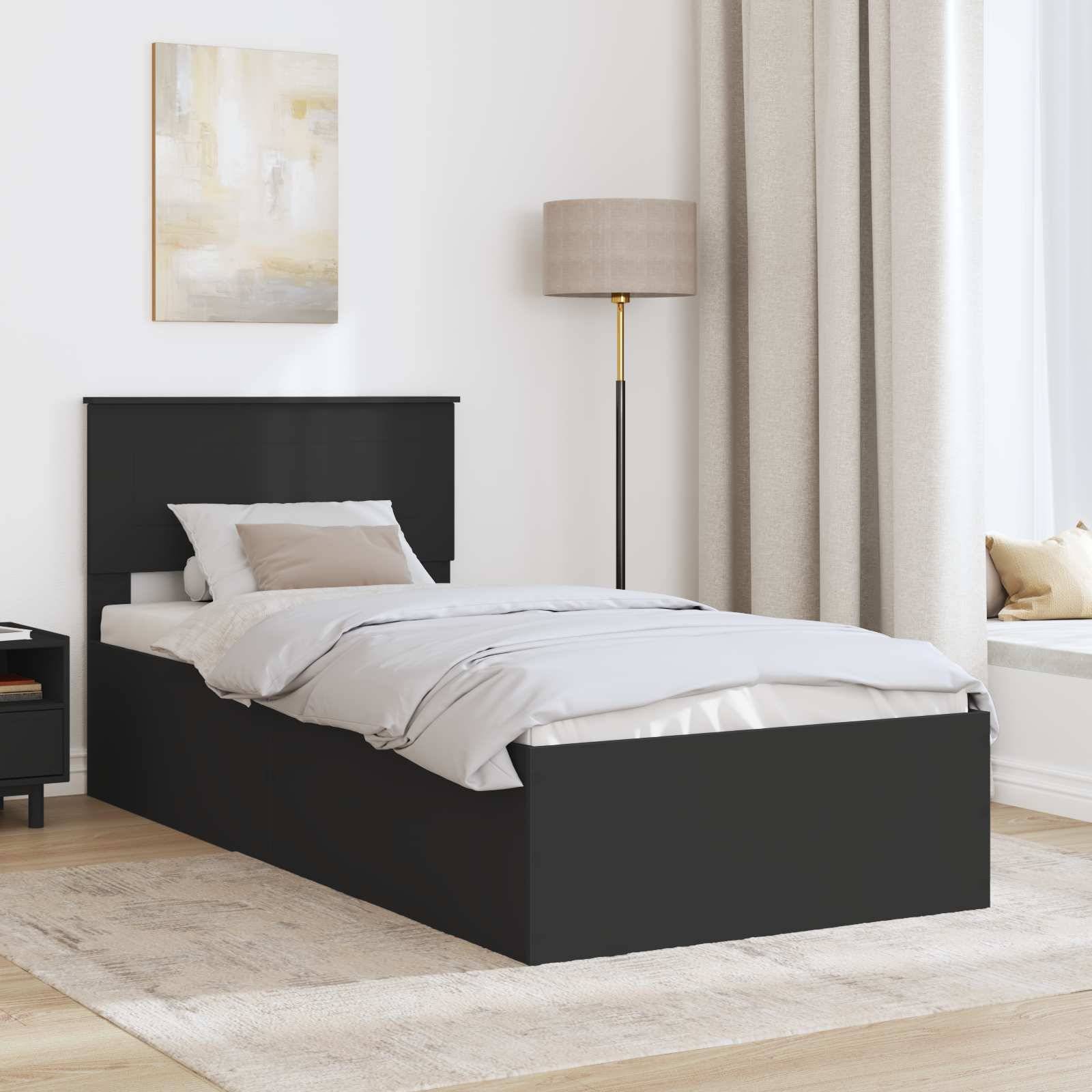 Ein modernes Schlafzimmer mit einem schwarzen Bett, weißer Bettwäsche, beigen Kissen, einer hohen Lampe, einem kleinen Nachttisch mit einem Buch und großen beigen Gardinen.