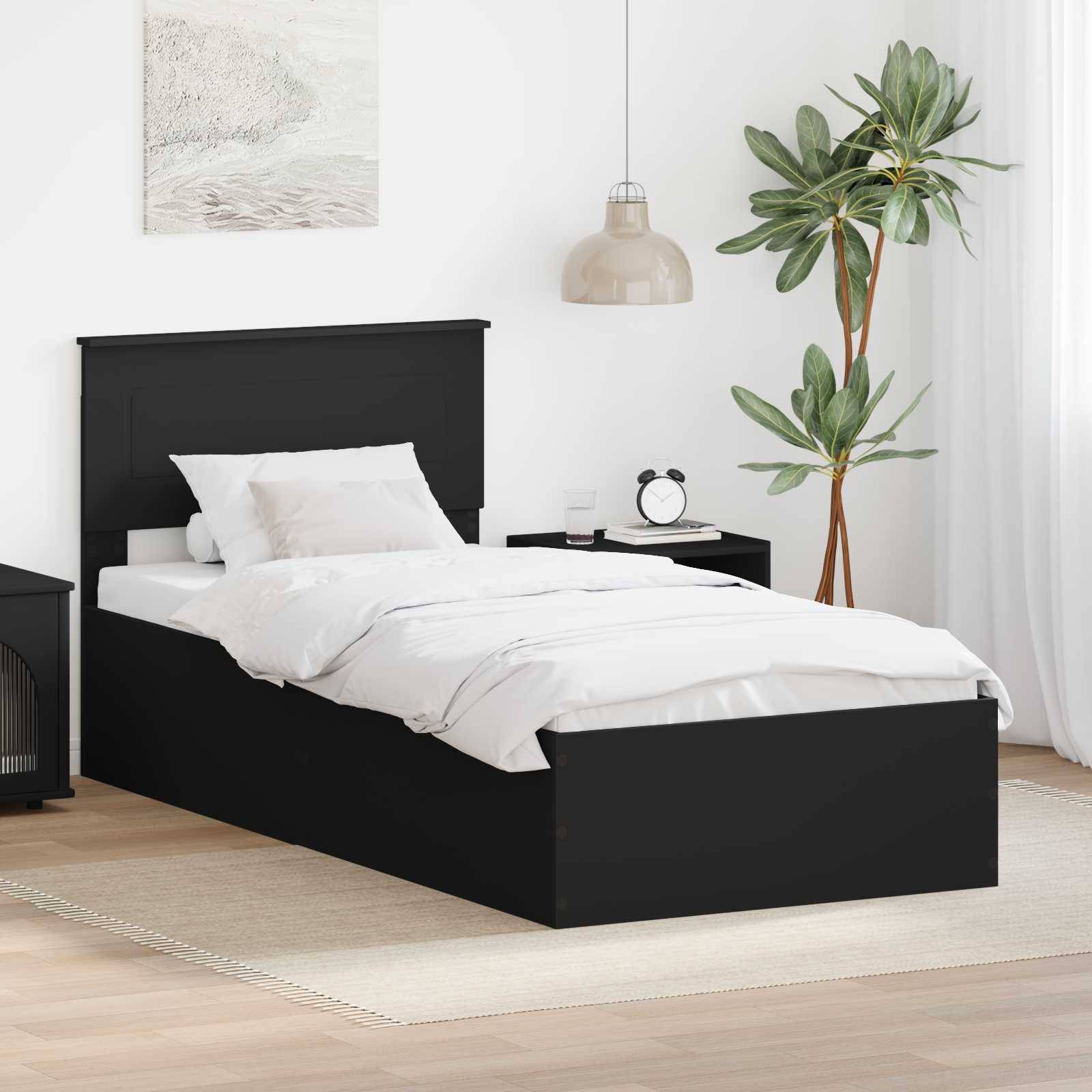 Ein modernes Schlafzimmer mit einem schwarzen Bett, weißer Bettwäsche, Nachttisch und einer Zimmerpflanze. Der Raum hat neutrale Töne und minimale Dekoration.