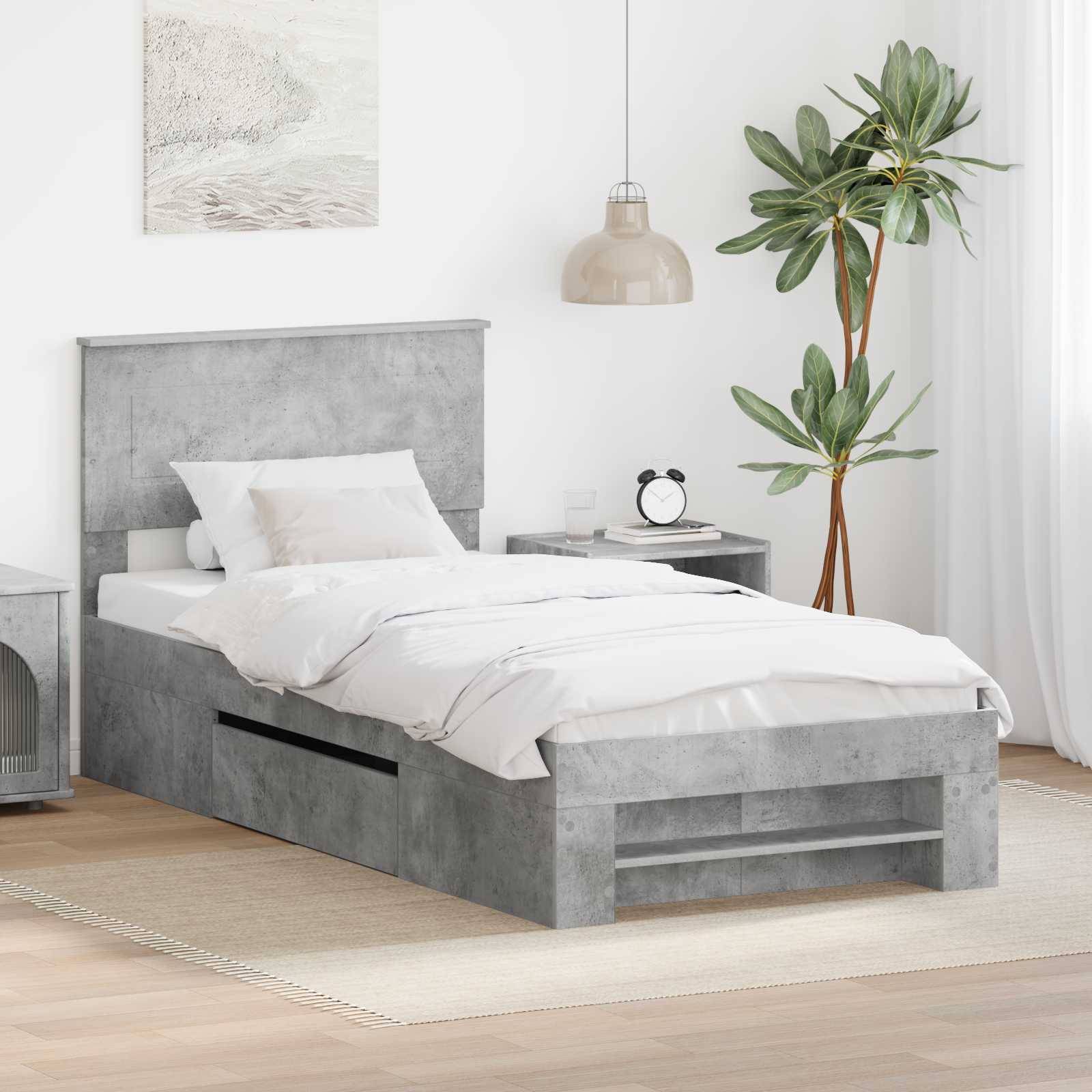 Modernes Schlafzimmer mit einem grauen Plattformbett, weißer Bettwäsche und einem Nachttisch. Eine Zimmerpflanze und ein gerahmtes Kunstwerk ergänzen die Dekoration.