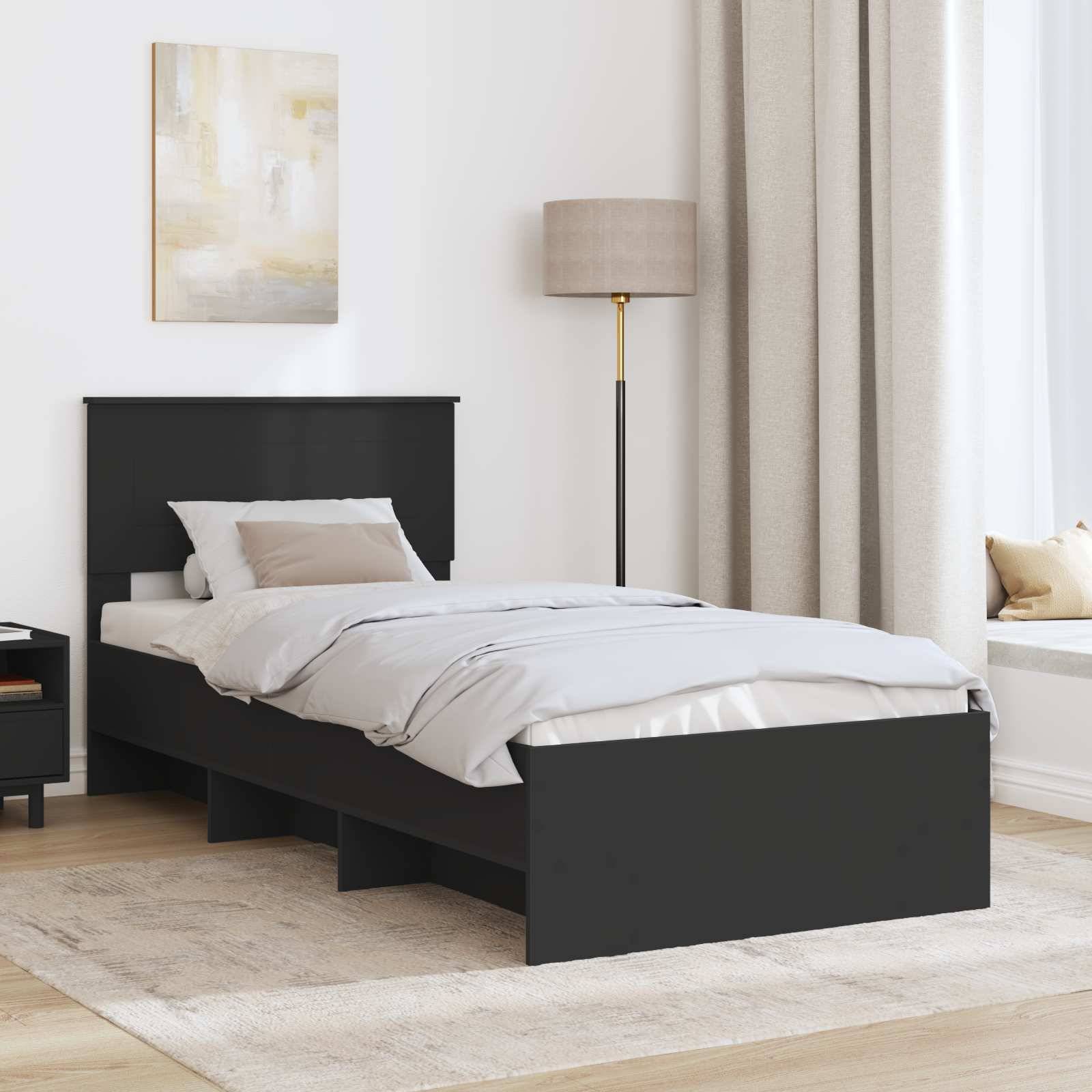 Ein modernes Schlafzimmer mit einem schwarzen Bett, heller Bettwäsche, einem Nachttisch und einer Stehlampe. Neutrale Töne dominieren die Raumgestaltung.